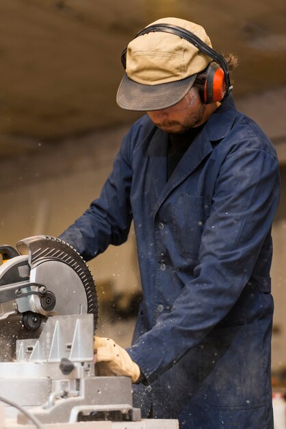 Professional carpenter uses circular saw in workshop