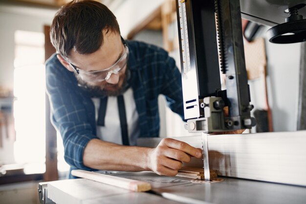 professional carpenter working with sawing machine
