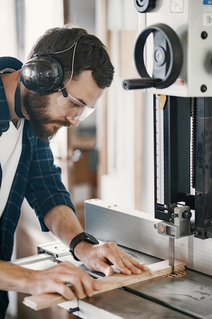 Professional carpenter working with sawing machine