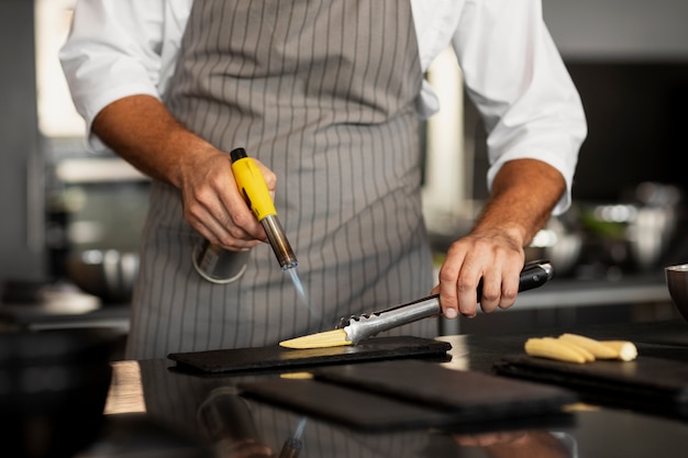 Foto gratuita chef professionista che prepara il cibo in cucina