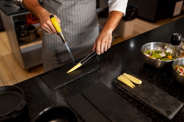 Foto gratuita chef professionista che prepara il cibo in cucina