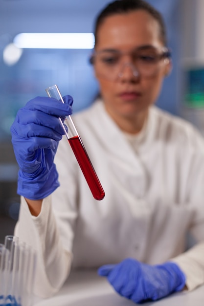 Professional chemist with test tube for blood in hand