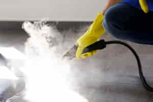 Free photo professional cleaning service person using steam cleaner in office