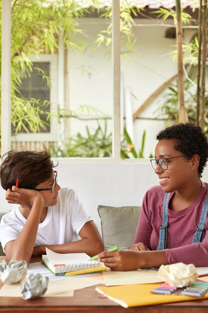 Professional dark skinned designer explains how make project work to male trainee