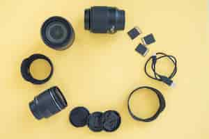 Free photo professional digital camera accessories arranged in circle over yellow background