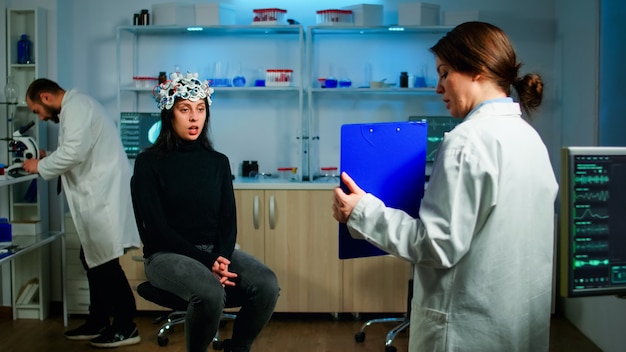 Professional doctor in neurological medicine testing eyesight of patient with eeg headset