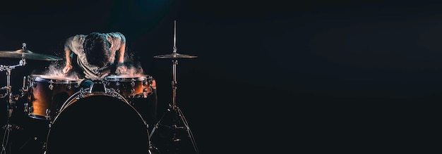 Free photo professional drummer playing on drum set on stage on the black background