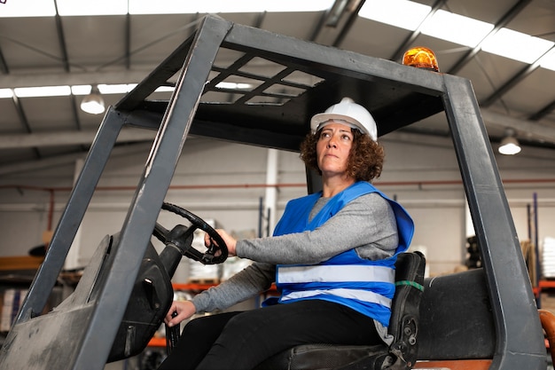 Free photo professional female driver operating forklift vehicle