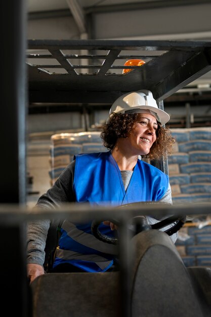 Professional female driver operating forklift vehicle