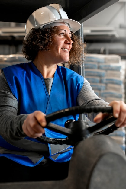 Foto gratuita autista professionista che utilizza un veicolo per carrelli elevatori