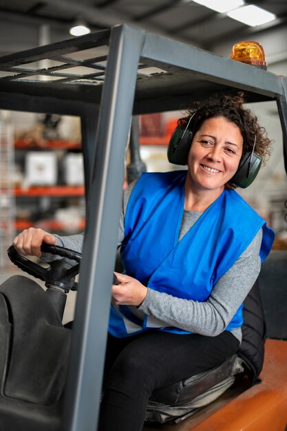 Professional female driver operating forklift vehicle