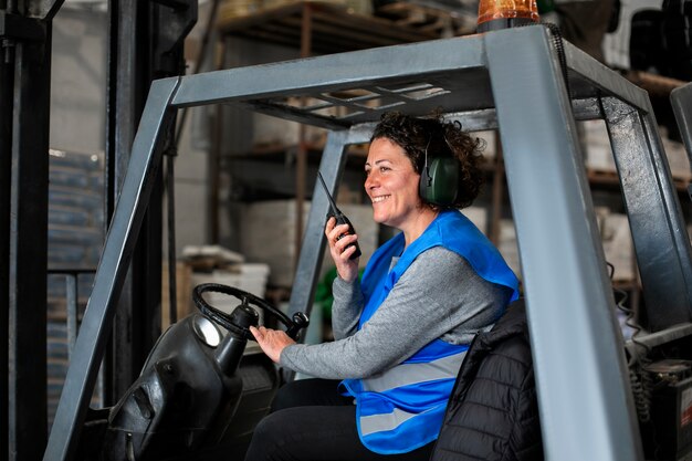 Foto gratuita autista professionista che utilizza un veicolo per carrelli elevatori