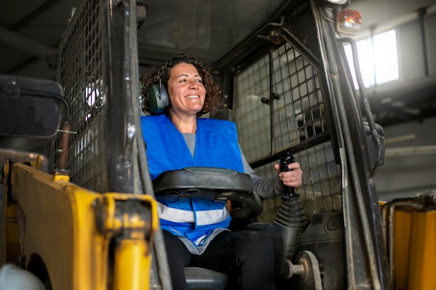 Foto gratuita autista professionista che utilizza un veicolo per carrelli elevatori