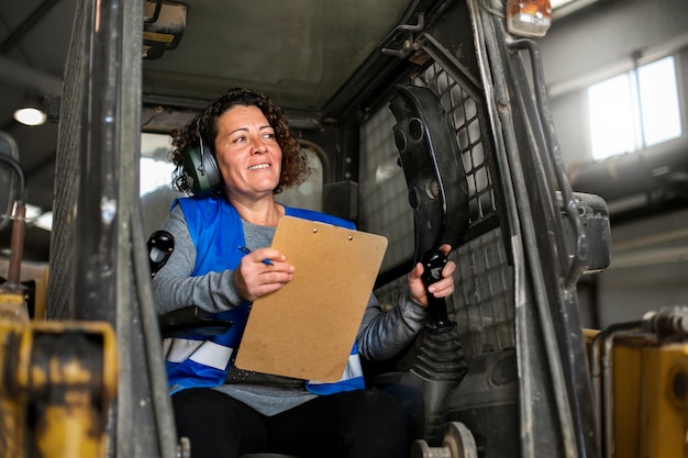 Foto gratuita autista professionista che utilizza un veicolo per carrelli elevatori