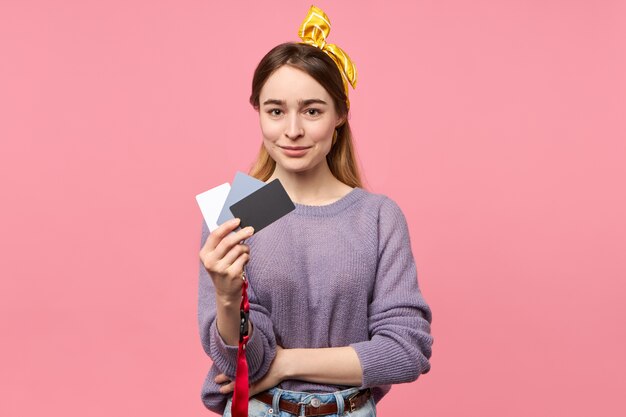 Professional female photographer holding white, gray and black cards to adjust exposure and white balance settings