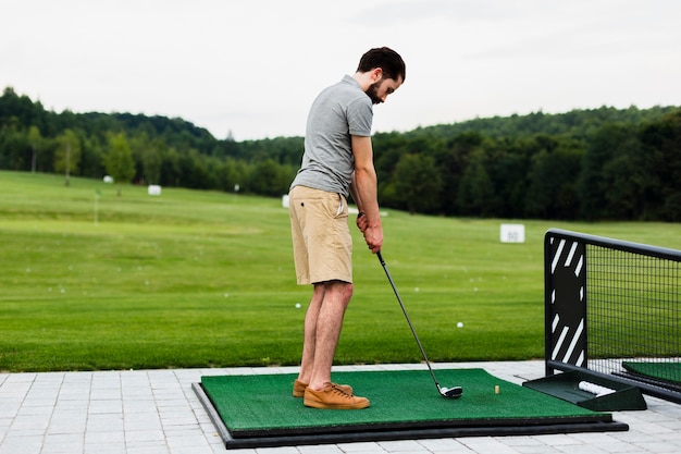 Free photo professional golf player practising on a golf field