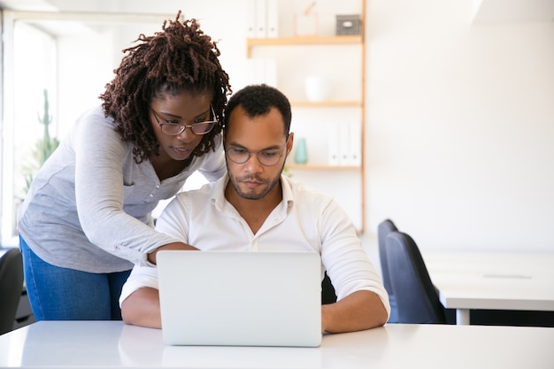 Professional helping new employee with report