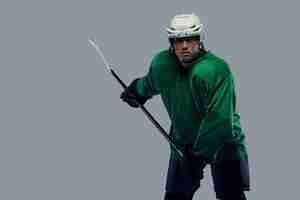 Free photo professional hockey player trains in full equipment with gaming stick. isolated on a gray background.