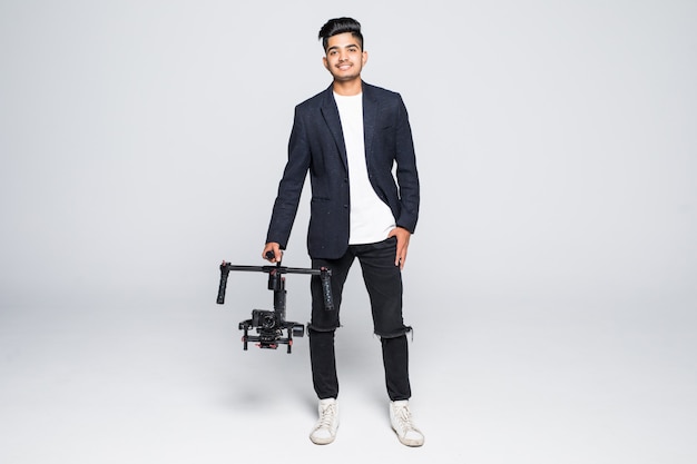 Professional indian man videographer with gimball video slr ronin isolated on studio background