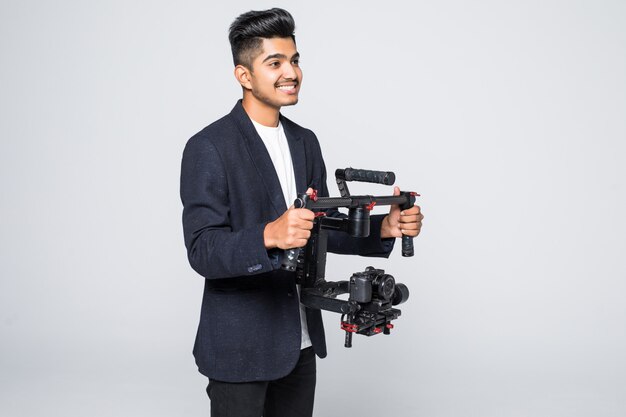 Professional indian man videographer with gimball video slr ronin isolated on studio background