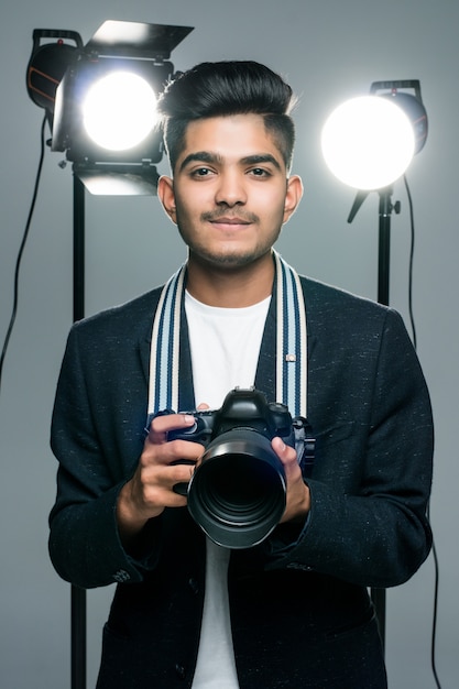 Professional indian young photographer taking photos in studio with leight