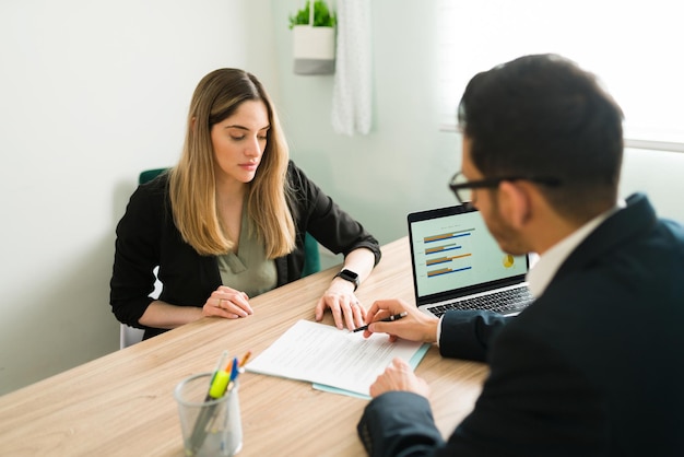 Foto gratuita avvocato professionista che spiega e rivede un contratto commerciale con una cliente in ufficio. donna caucasica che ascolta il suo capo maschio parlare di un rapporto di lavoro