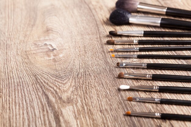 Professional make-up brushes on wooden background. Beauty industry