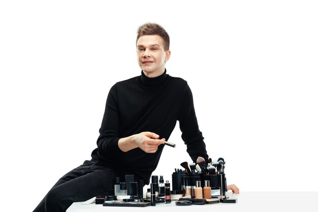 Free photo professional makeup artist with tools isolated on white . the man in female profession. gender equality concept