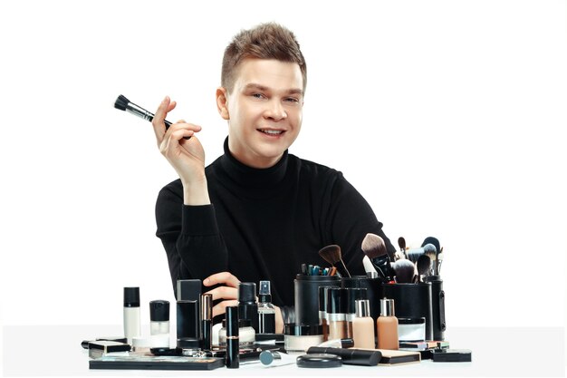 Professional makeup artist with tools isolated on white studio background. The man in female proffesion. gender equality concept