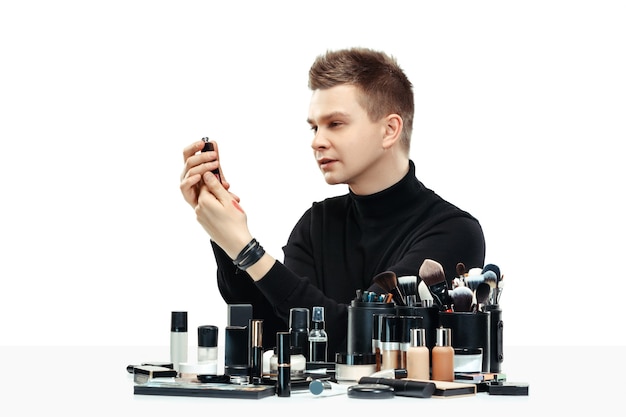 Free photo professional makeup artist with tools isolated on white studio background. the man in female proffesion. gender equality concept