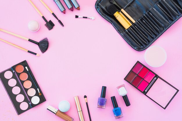 Professional makeup products with cosmetic beauty products on pink background