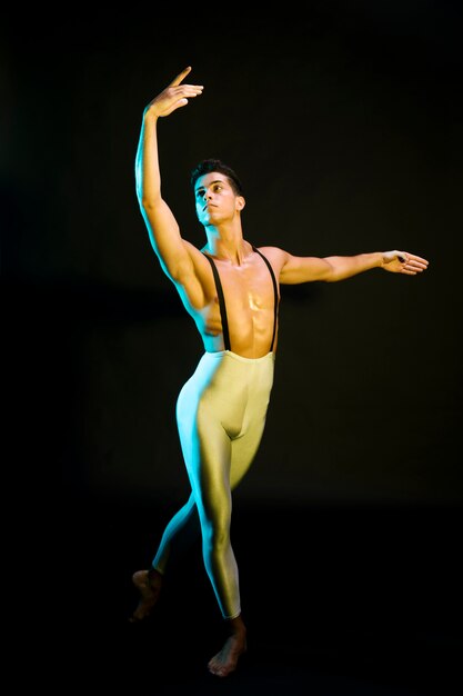 Professional male ballet dancer performing in spotlight