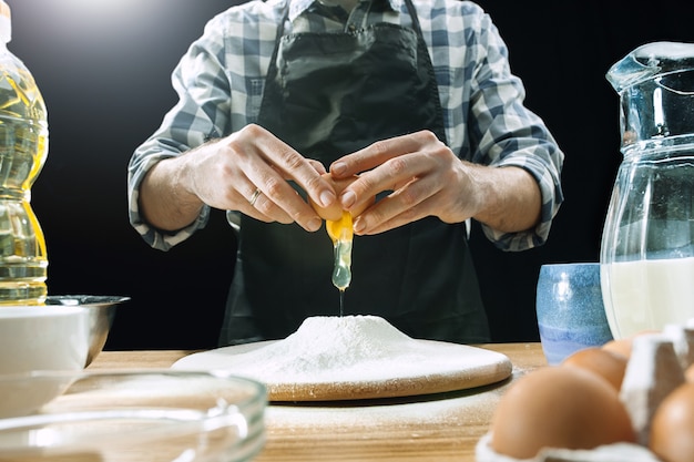 Il cuoco maschio professionista spruzza la pasta con la farina