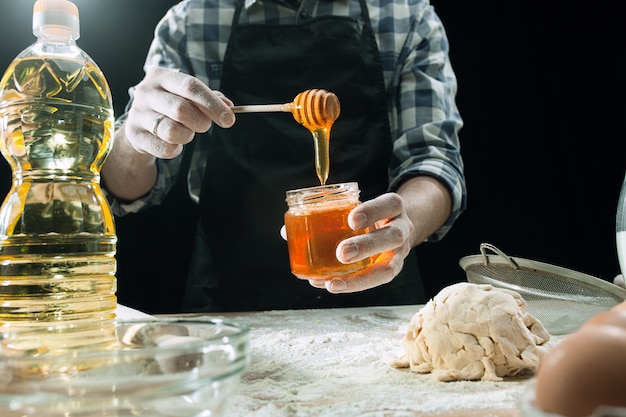 Профессиональный мужской повар использует мед для приготовления