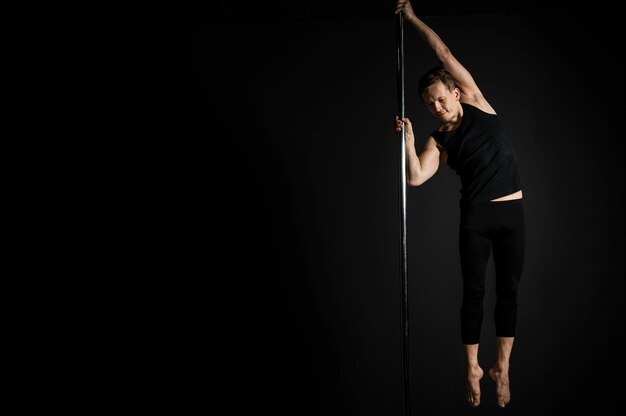 Professional male doing a pole dance