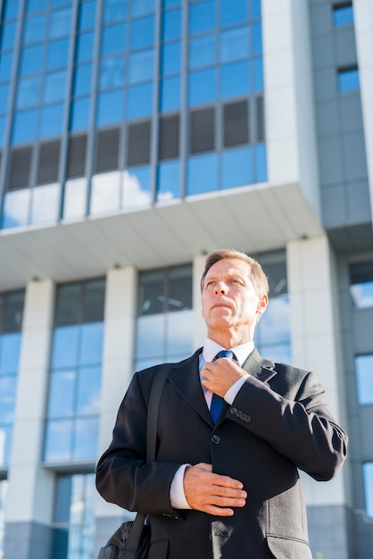 Professional mature man standing in front of building