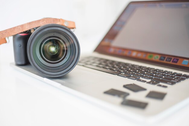 Professional modern camera and memory cards on laptop