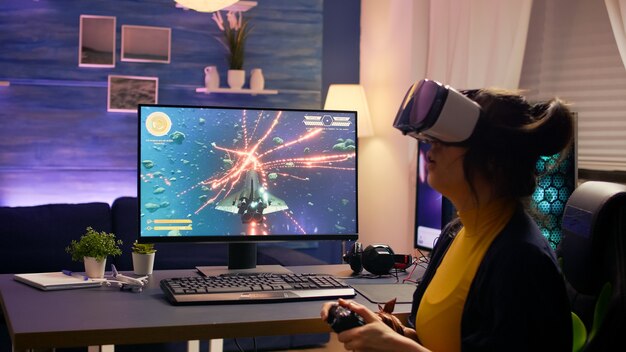 Professional player wearing vr goggles sitting on gaming chair playing online space shooter game