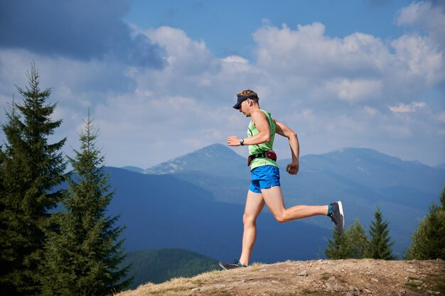 Professional runner training run downhill in the mountains