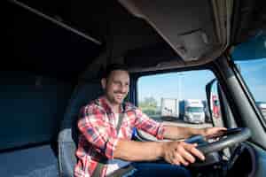 Foto gratuita autista di camion professionista in abbigliamento casual che indossa la cintura di sicurezza e guida il suo camion a destinazione