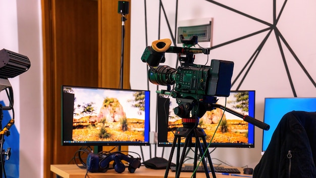 스튜디오의 테이블에 모니터가 있는 스탠드에 있는 전문 비디오 카메라. 가상 프로덕션