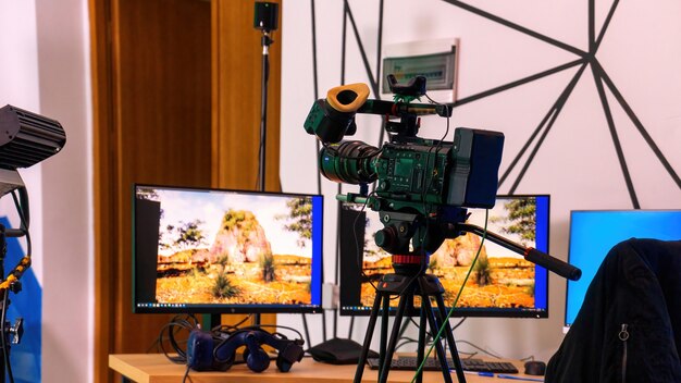 스튜디오의 테이블에 모니터가 있는 스탠드에 있는 전문 비디오 카메라. 가상 프로덕션