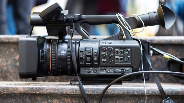 Professional video camera with cables on stone stairs