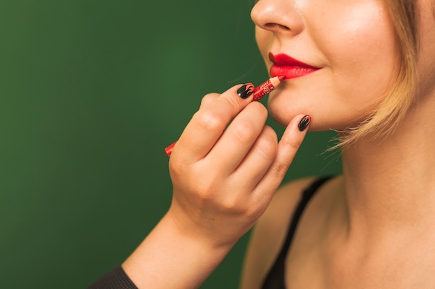 Professional woman making up girl's lips