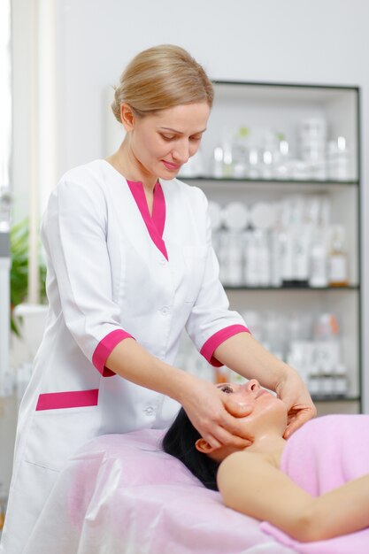 Professional woman massaging the client's face