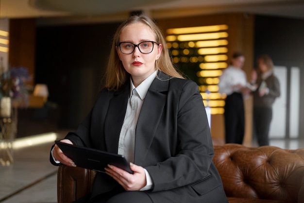 Free photo professional woman in stylish suit at the office with tablet device