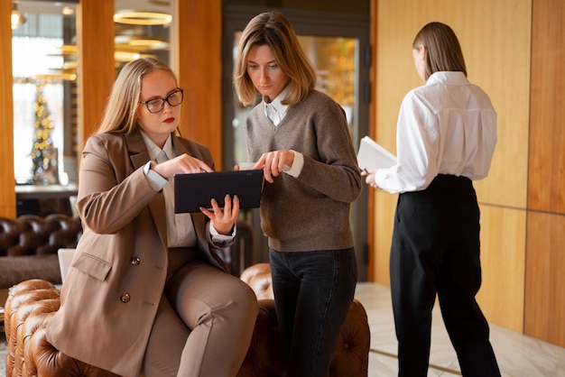 Бесплатное фото Профессиональные женщины в стильном костюме в офисе с планшетным устройством