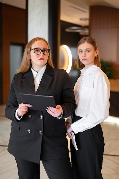 Professional women in stylish suit at the office with tablet device