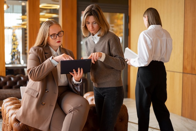 Free photo professional women in stylish suit at the office with tablet device