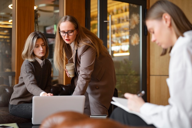 Professional women in stylish suit working with laptop at the office